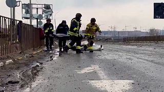 As Russian forces "pushed back" from Irpin, Ukrainian rescuers collect dead bodies in Irpin
